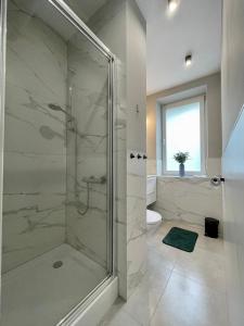 a bathroom with a shower with a glass door at Przytulny apartament niedaleko dworca PKP in Radom