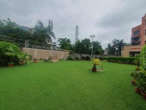 un gran patio con césped verde y plantas en Hotel Shrinath Palace, en v
