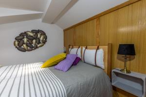 a bedroom with a bed with purple and yellow pillows at A Casa da Rapariga de Cabelo Azul in Manteigas
