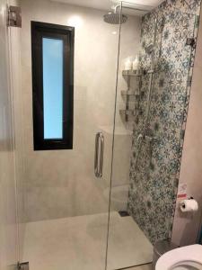 奈扬海滩2 Bedroom Apartment in Naiyang - The Title Residences, Naiyang的带玻璃门淋浴间的浴室