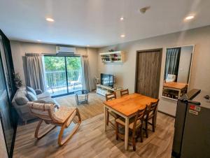 uma sala de estar com uma mesa de madeira e uma cozinha em 2 Bedroom Apartment in Naiyang - The Title Residences, Naiyang em Praia de Nai Yang