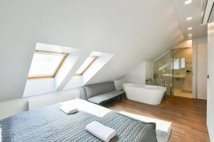 Schlafzimmer im Dachgeschoss mit einem Bett und einer Badewanne in der Unterkunft Luxury Apartment in Centre in Prag