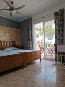 een slaapkamer met een bed en een glazen schuifdeur bij Hostal Bélgica in Palmanova