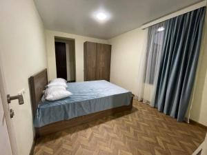 a bedroom with a bed with two pillows on it at Flats at Era Square in Batumi