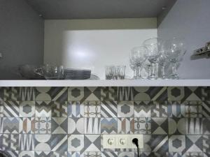 a shelf with wine glasses and plates on it at Flats at Era Square in Batumi