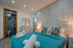 - une chambre avec un grand lit bleu et deux oreillers dans l'établissement Few minutes from Valletta modern 2-bd roof top apartment, à Marsa