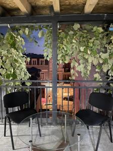 two chairs and a glass table in front of a window at Flats at Era Square in Batumi