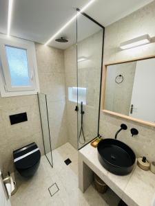 a bathroom with a black sink and a shower at Scala Apartments in Kastraki Naxou