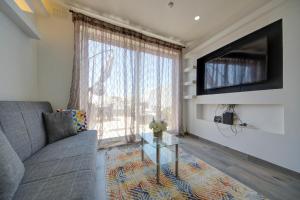 - un salon avec un canapé et une télévision dans l'établissement Few minutes from Valletta modern 2-bd roof top apartment, à Marsa