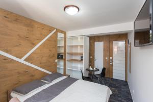 a bedroom with a bed and a wooden wall at Tilia in Cetinje