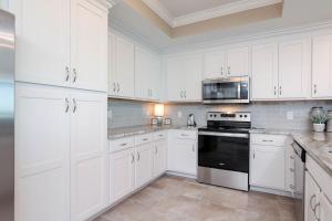 a white kitchen with white cabinets and a microwave at Phoenix Orange Beach II 1104 in Orange Beach