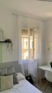 - une chambre avec un lit, une fenêtre et un bureau dans l'établissement Residencia Santa Bárbara, à Grenade