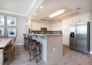 a kitchen with a stainless steel refrigerator and a table at Phoenix Orange Beach II 1202 condo in Orange Beach