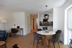 cocina y sala de estar con mesa blanca y sillas en Ferienwohnung Amalie, en Füssen