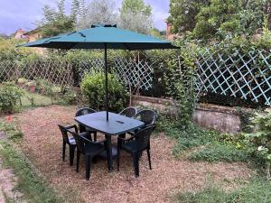 a table and chairs with an umbrella in a yard at Appartamento Michele in Greve in Chianti
