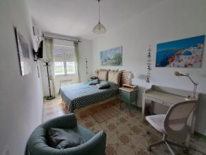 1 dormitorio con cama, silla y escritorio en CASA DI ANDREA, en Albenga