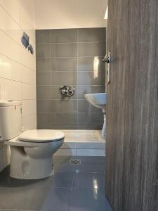 łazienka z toaletą i umywalką w obiekcie Lixourious Apartment w Lixoúrion