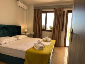 a bedroom with a bed with towels on a table at Lixourious Apartment in Lixouri