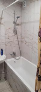 a bathroom with a bath tub and a sink at Квартира на Агнии Барто in Dnipro
