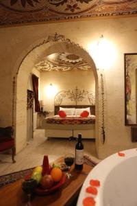 um quarto com uma cama com uma tigela de fruta numa mesa em Corner İn Cappadocia em Ortahisar