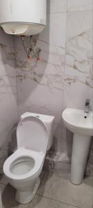 Łazienka z białą toaletą i umywalką w obiekcie Квартира на Агнии Барто w mieście Dniepr