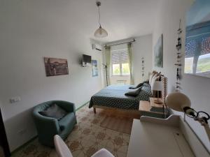 1 dormitorio con 1 cama y 1 silla en una habitación en CASA DI ANDREA, en Albenga