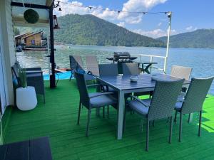 una mesa y sillas en la cubierta de un barco en Casa pe lac Bicaz, en Bicaz