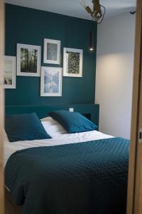 Un dormitorio con una pared de acento azul y una cama en L'AuthentiK, en Guingamp