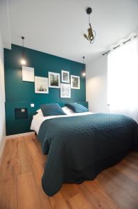 1 dormitorio con 1 cama grande y pared verde en L'AuthentiK, en Guingamp