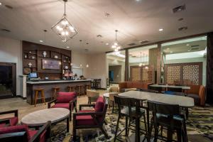a restaurant with tables and chairs and a bar at SpringHill Suites by Marriott Denton in Denton