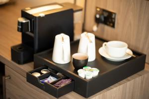 ein Tablett mit zwei Tassen und einer Kaffeemaschine in der Unterkunft Marks Tey Hotel Colchester in Colchester