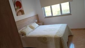 a small bedroom with a bed and a window at Beiramar4 in Muxia
