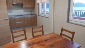a kitchen with a wooden table and two chairs at Beiramar4 in Muxia