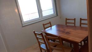 a wooden table and chairs in a room with a window at Beiramar4 in Muxia +3 photos