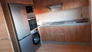 a kitchen with a stainless steel refrigerator and a washer at Beiramar4 in Muxia