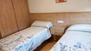 a small bedroom with two beds and a night stand at Beiramar4 in Muxia