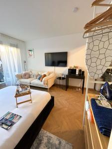 ein Wohnzimmer mit einem Sofa und einem TV in der Unterkunft Monaco Cap d’ail Studio & jardin in Cap d'Ail