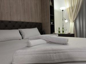 ein Schlafzimmer mit einem weißen Bett und Handtüchern darauf in der Unterkunft Alessia in Braşov