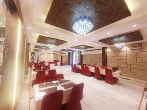 a restaurant with red chairs and tables in a room at Hotel Shrinath Palace in Jhānsi