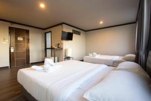 Postel nebo postele na pokoji v ubytování Pimpimarn Hotel