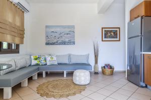 - un salon avec un canapé bleu et un réfrigérateur dans l'établissement Lemon Casa, à Skopelos