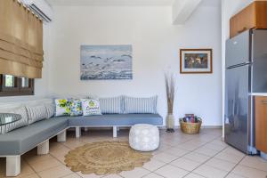 a living room with a blue couch and a refrigerator at Lemon Casa in Skopelos Town