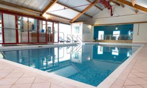 ein großer Pool in einem Gebäude in der Unterkunft Marks Tey Hotel Colchester in Colchester