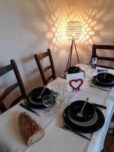 a table with a white table cloth with plates and glasses at Au cabanon de Lisle in Lisle-sur-Tarn