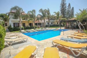 Una piscina con tumbonas y un resort. en Petros Village - A Private Escape, en Hersonissos