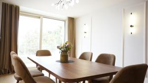 a dining room with a wooden table and chairs at Beachfront 2BR Apartment with Balcony and Sea View, Biser Mora in Rafailovici