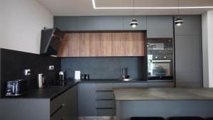 a kitchen with wooden cabinets and a counter top at Beachfront 2BR Apartment with Balcony and Sea View, Biser Mora in Rafailovici