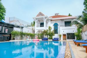 eine Villa mit einem Pool vor einem Haus in der Unterkunft The Big Easy Siem Reap in Siem Reap