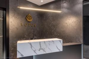 a lobby of a store with a lotus sign on the wall at Lotus Luxury Rooms in Varna City