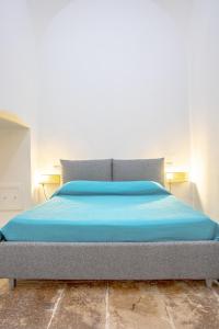 - un lit avec des draps bleus dans une chambre dans l'établissement Senso Unico: nuovo appartamentino in centro, à Bisceglie